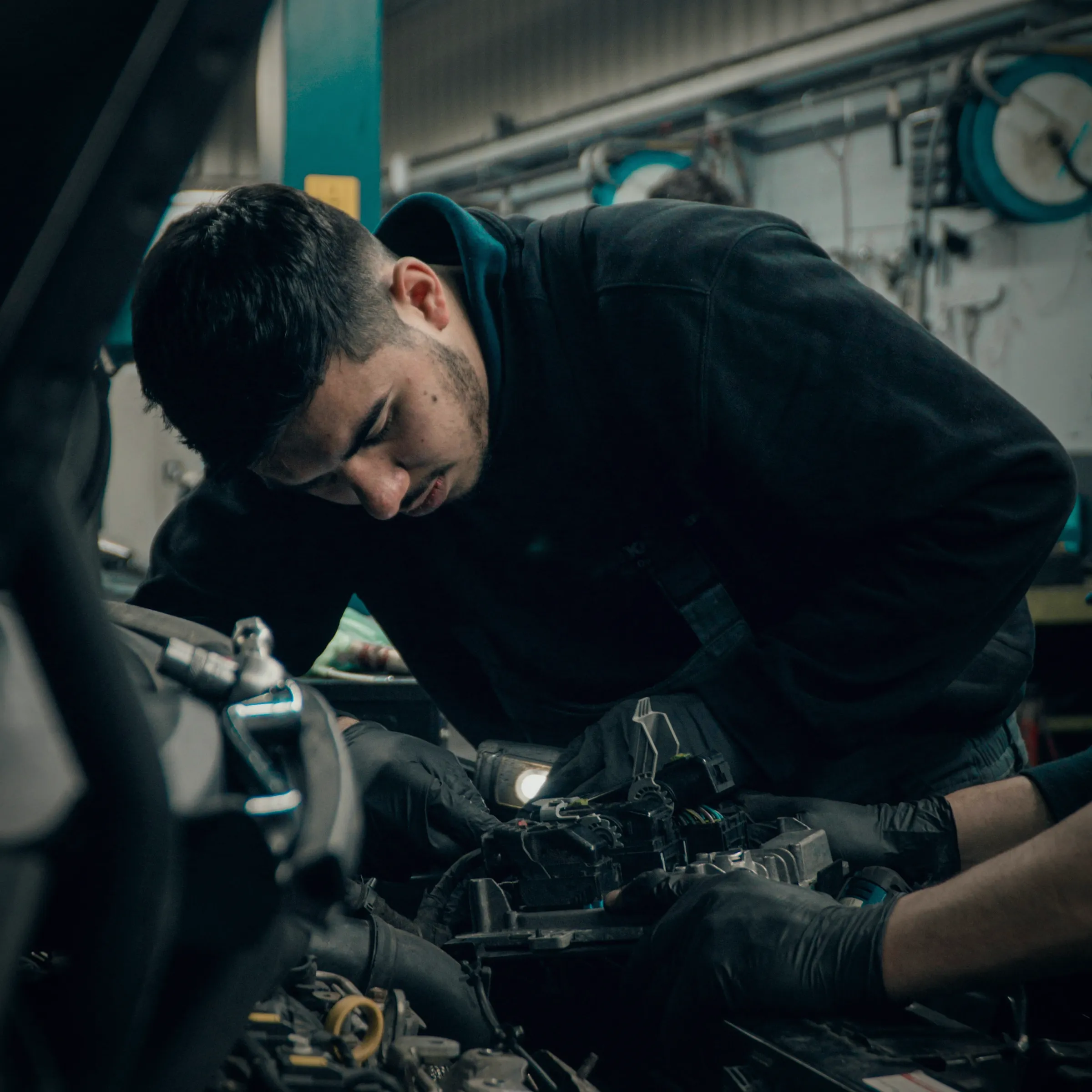 A technician working in the engine bay of a modern car